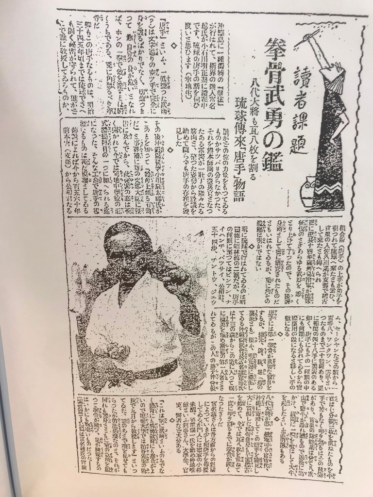 Uma página de jornal antiga com texto em japonês, incluindo uma imagem de um homem vestindo uma camisa branca, segurando algo com a mão. O fundo apresenta uma variedade de textos e informações, possivelmente relacionadas a artes marciais ou cultura japonesa.